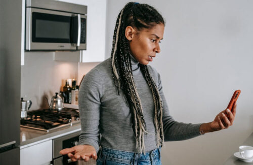 Woman looking at phone frustrated