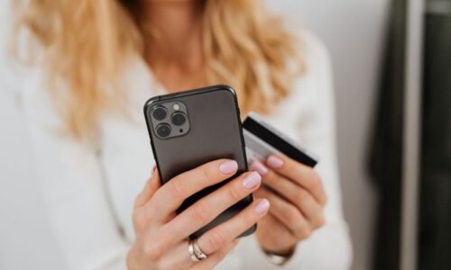 Lady holding iPhone and a bank card