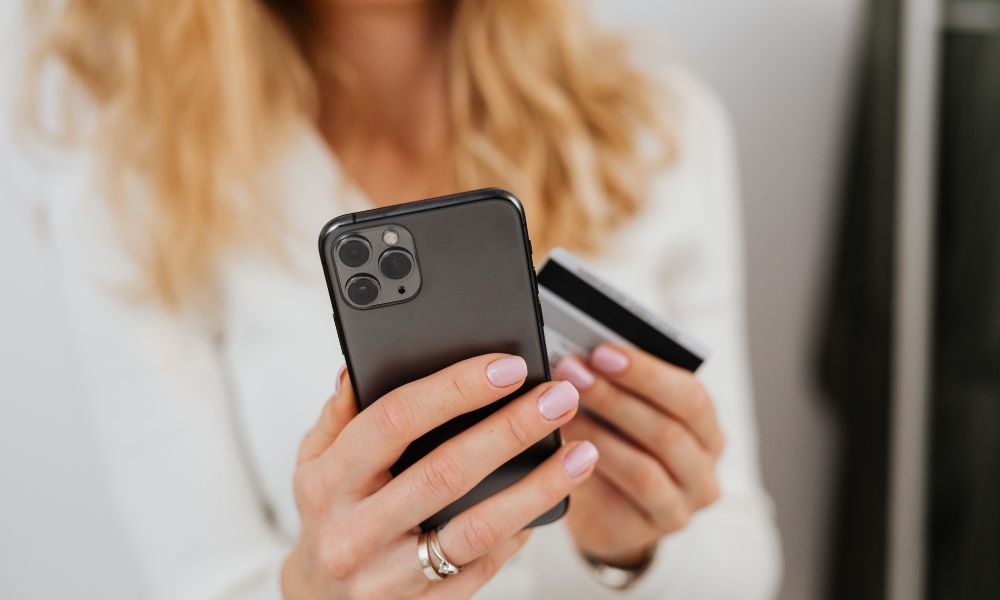 Lady holding iPhone and a bank card